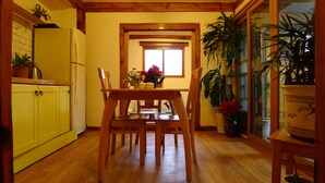 A kitchen with wooden cabinets, a dining table with chairs, and various potted plants. - HanOK Guest House 202 (Seoul)