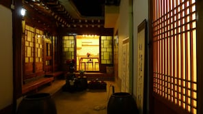 A traditional Japanese interior with tatami mat flooring, a low table with chairs, and a sliding door with calligraphy. - HanOK Guest House 202 (Seoul)