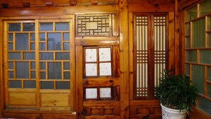 A traditional wooden room with multiple windows, including a large sliding door and a set of shoji screens. - HanOK Guest House 202 (Seoul)