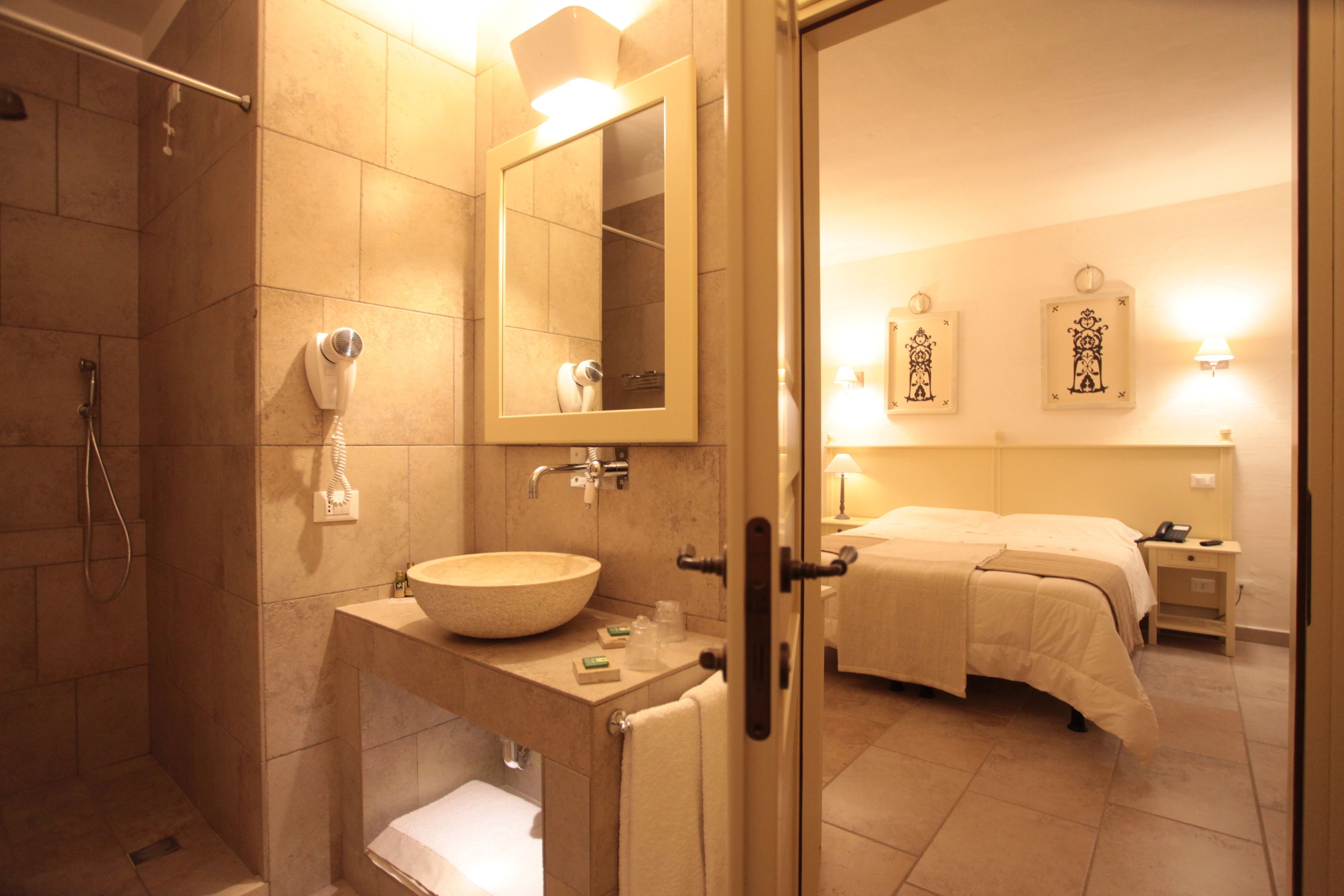 Une salle de bain avec un grand lavabo, un miroir et une douche.