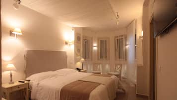 Une chambre d’hôtel avec un grand lit, des tables de chevet avec des lampes, une armoire et un miroir.