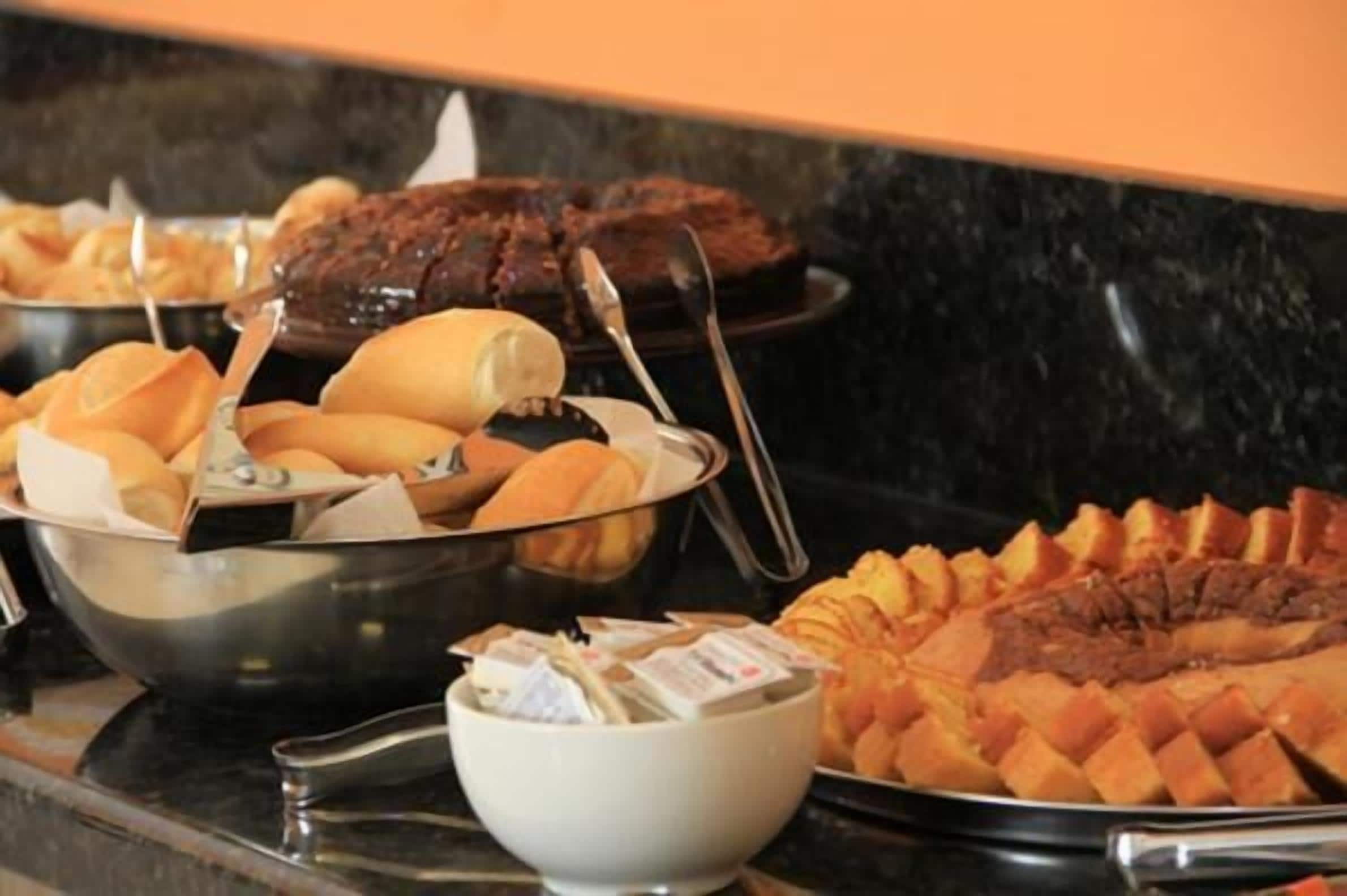 Un bufé con diversos platos, incluyendo un pastel grande, pan y un tazón de sopa.