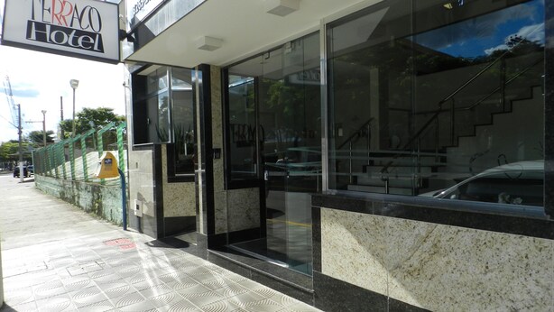 The exterior of the Terraco Hotel with a modern facade, large glass windows, and a visible staircase leading to the entrance. - Terraço Hotel (Tres Pontas)