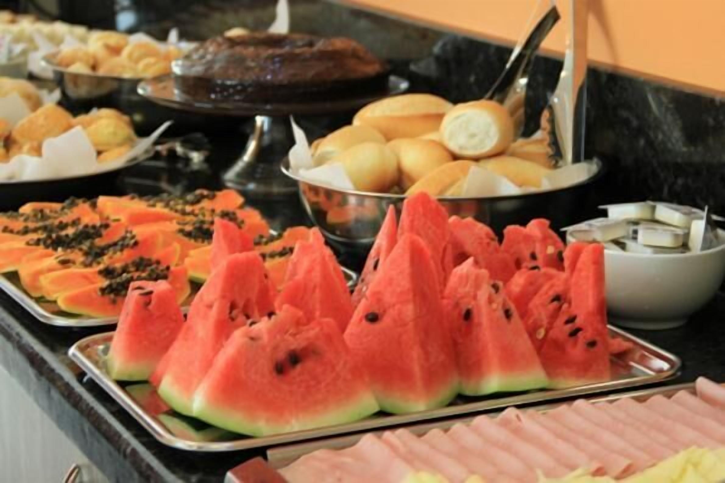 A buffet with various food items including watermelon slices, bread, and other dishes.
