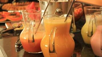 A buffet with various food items and drinks, including orange juice in pitchers.