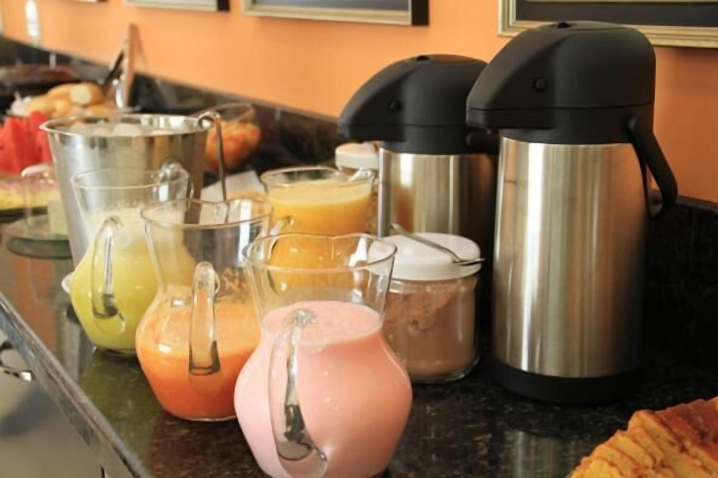 Un bufé de desayuno con diferentes alimentos y una cafetera.