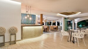 Un vaste espace intérieur comprenant un comptoir d’accueil, un plancher en bois et de nombreux espaces aménagés pour s’asseoir.