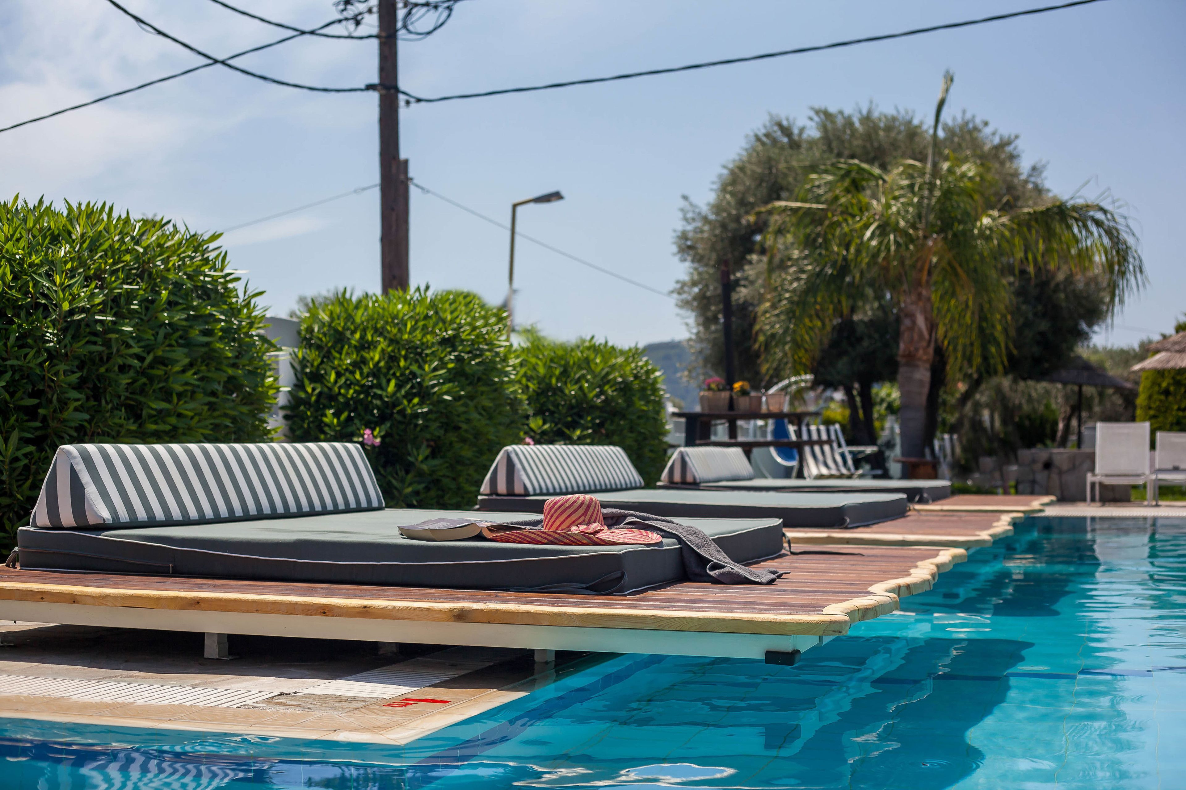 A poolside area with lounge chairs and a wooden deck.