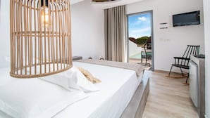 Une chambre d’hôtel moderne équipée d’un lit, d’une télévision, d’un bureau et offrant une vue sur l’extérieur.