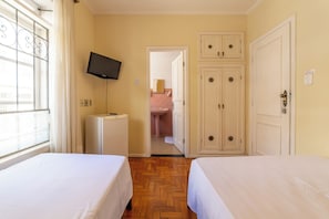 A hotel room with two beds, a television, a wardrobe, and a bathroom visible through an open door. - Hotel Solaris (Sao Lourenco)