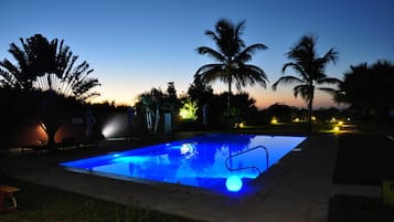 Relax by the pool surrounded by palm trees and lush greenery.