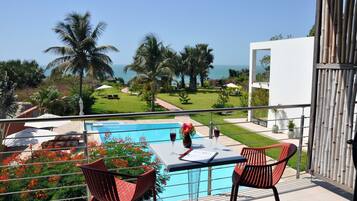 Enjoy a refreshing view of the pool and lush surroundings from this balcony.