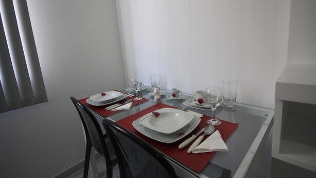 Taula de dinar preparada amb plats, gots i coberts, i una cadira col·locada a la taula.