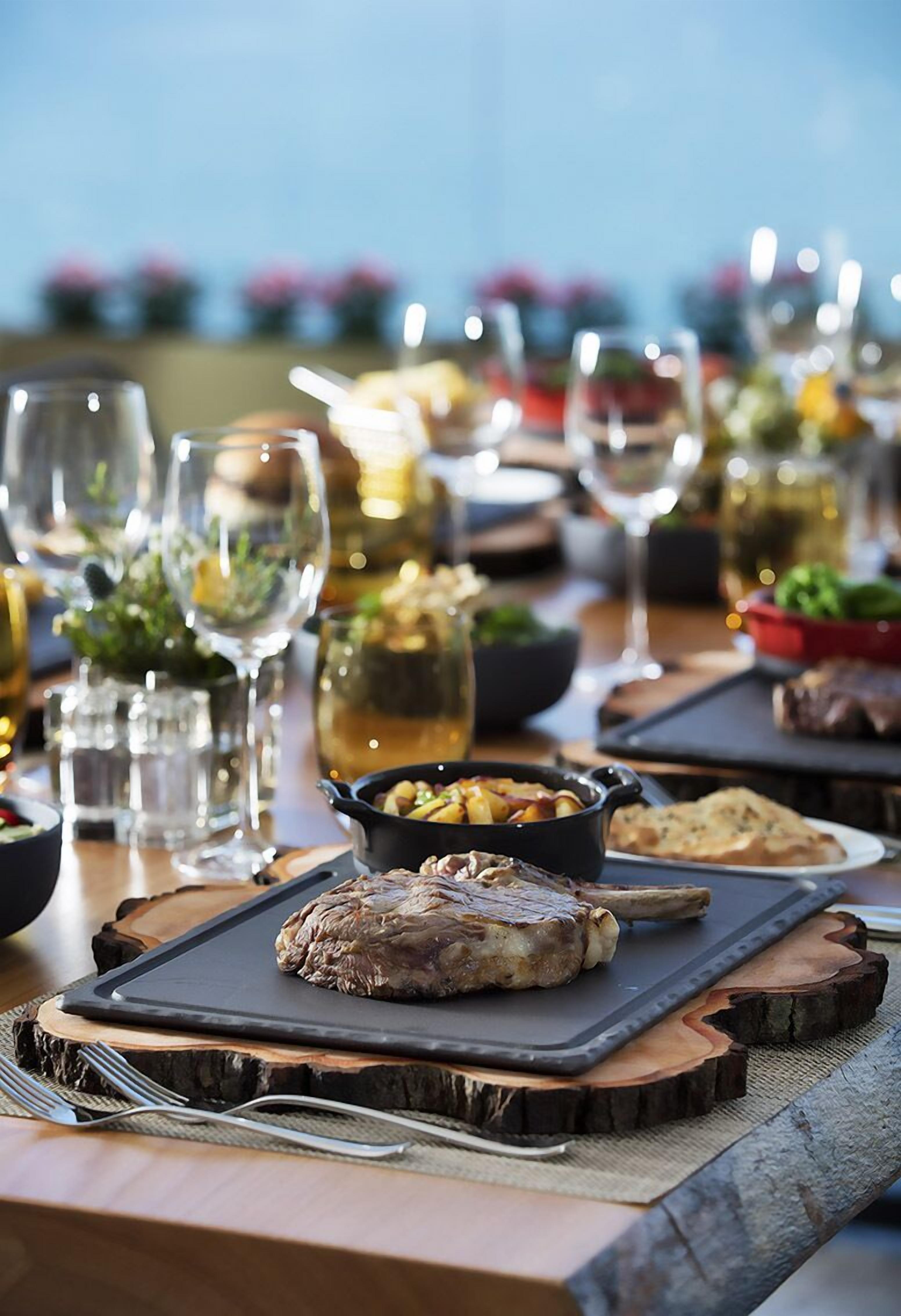 A dining table set with various dishes, glasses, and a wine bottle.
