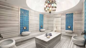 Features a central sink, two smaller sinks, and a striking chandelier.