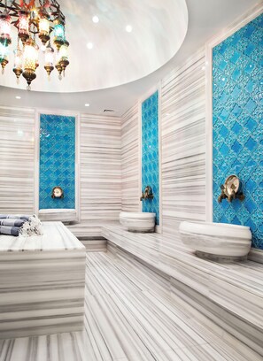 Ein luxuriöses Badezimmer mit Marmorwänden, zwei Waschbecken und einer großzügigen Badewanne.
