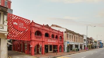 A street view with a prominent red building labeled "The Red House" and adjacent shops.