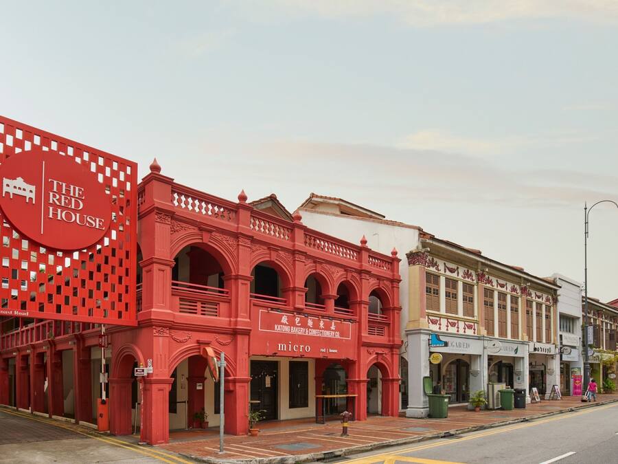 A street view with a prominent red building labeled "The Red House" and adjacent shops.
