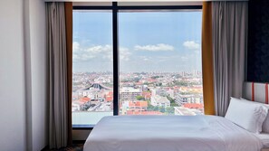 Ein Hotelzimmer mit großem Fenster und Blick auf die Stadt.