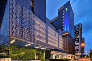 A modern building with a patterned facade, a visible entrance, and a green wall with plants. - Holiday Inn Express Singapore Katong by IHG (Singapore)
