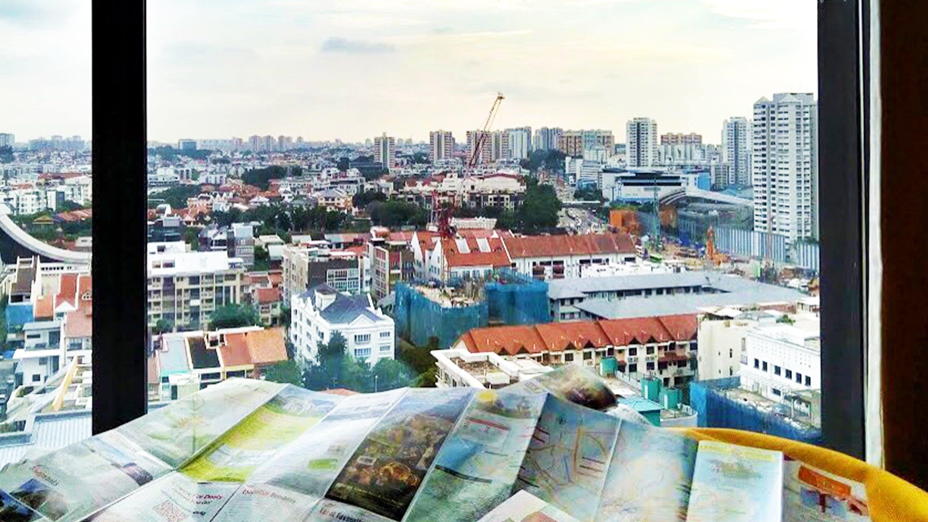 Un paisaje urbano con rascacielos, grúas de construcción y una mezcla de edificios residenciales y comerciales.