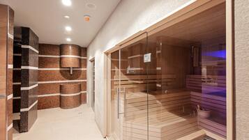 A modern spa area with a glass-enclosed sauna, tiled walls, and a wooden bench.