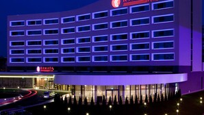 Moderni rakennus, jonka julkisivussa on selkeästi näkyvissä kyltti, jossa lukee ”RAMADA PLAZA”.