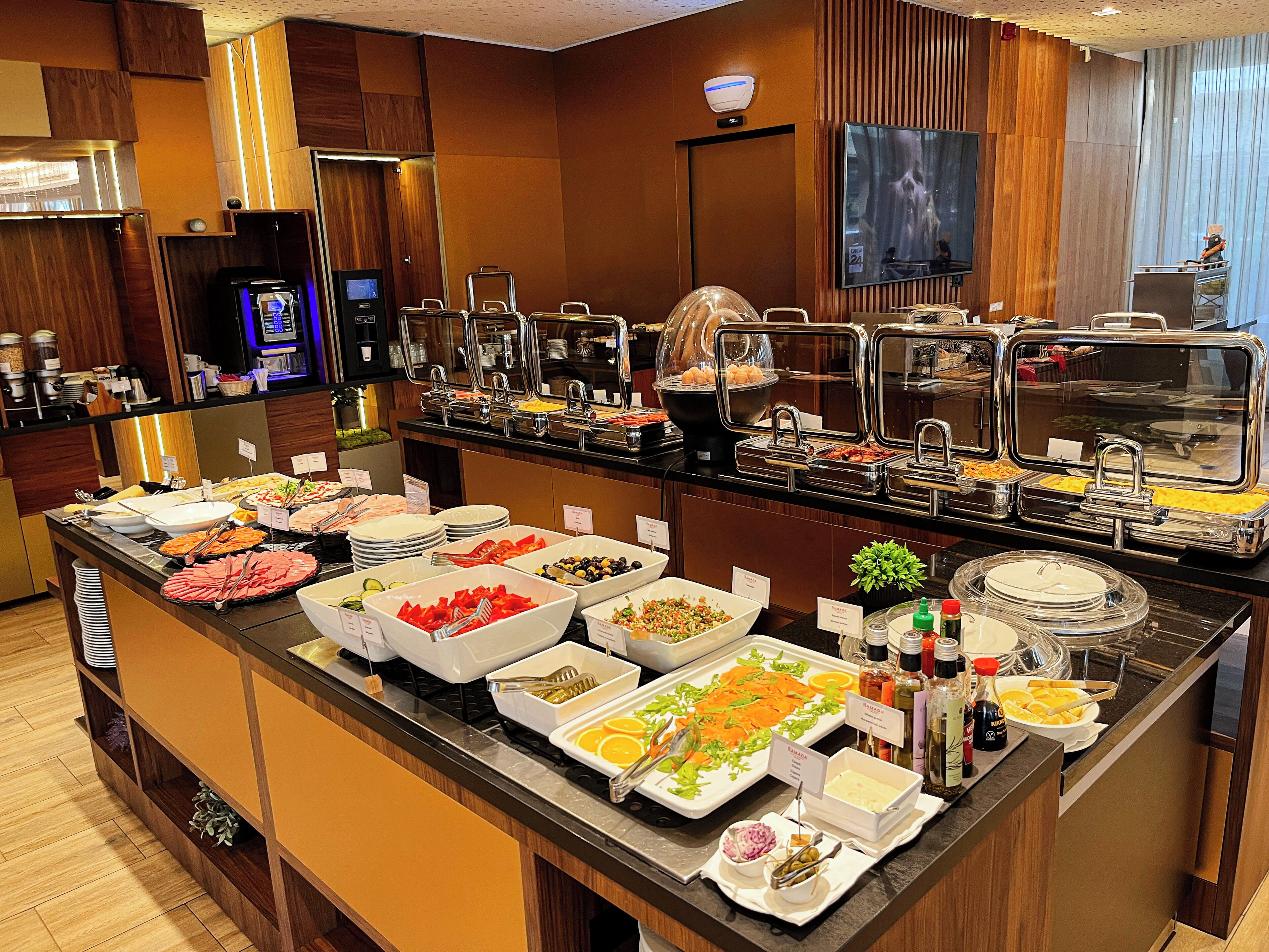 A buffet with various food options, a television, and a security camera.