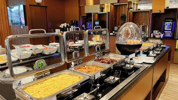 A buffet with various food options, including a large bowl of eggs, a tray of scrambled eggs, and several other dishes.