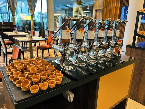 Una estación de café con varias máquinas de espresso y vasos tipo waffle.