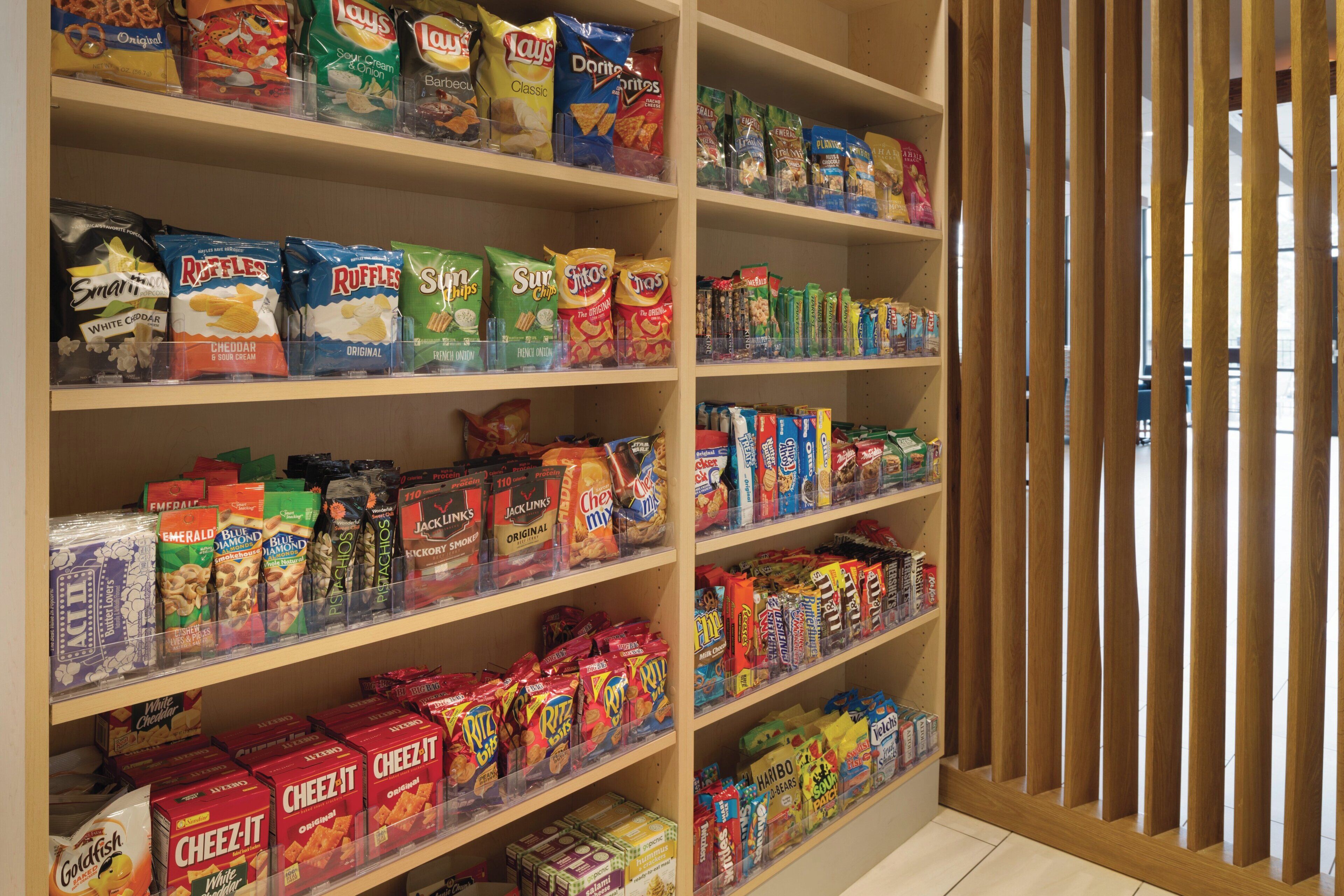 A snack aisle with various brands and types of chips, crackers, and other snacks.