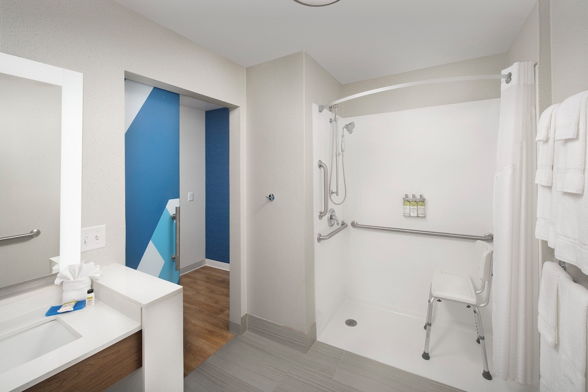 A modern bathroom with a shower, a toilet, and a sink.