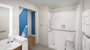 A modern bathroom with a shower, a toilet, and a sink.