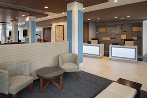A hotel lobby with seating, a reception desk, and a large wall with geometric patterns. - Holiday Inn Express Atlanta SW - Newnan by IHG (Newnan)