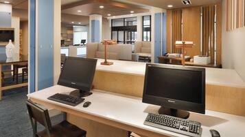 A modern office space with two desks, each equipped with a computer monitor, keyboard, and mouse.