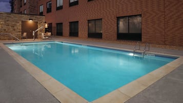 Una piscina al aire libre de temporada, tumbonas
