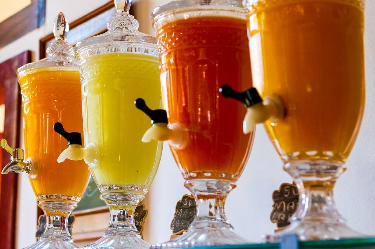 Een rij drankdispensers met tuitjes en hendels.