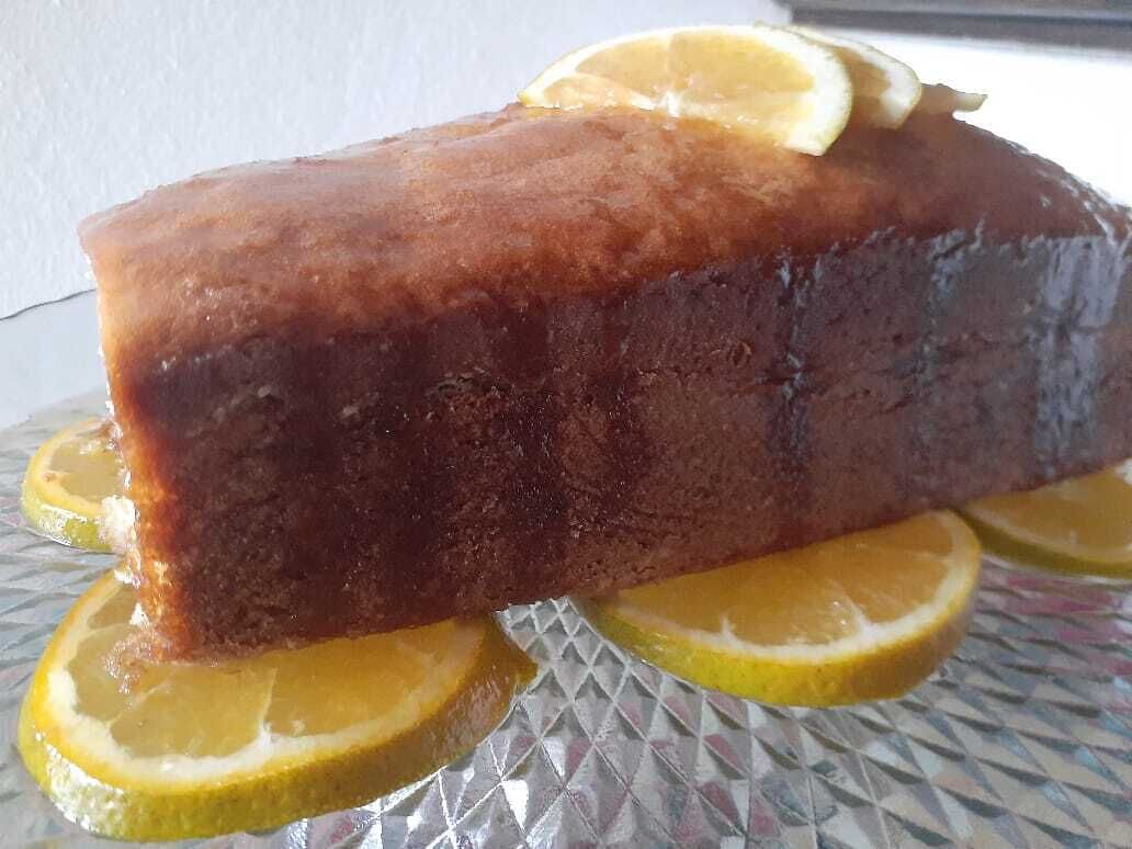 A loaf of bread with lemon slices on a glass plate.
