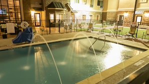 An indoor swimming pool with a covered slide, surrounded by a fence and chairs, with a building in the background. - Staybridge Suites Austin North - Parmer Lane by IHG (Austin)