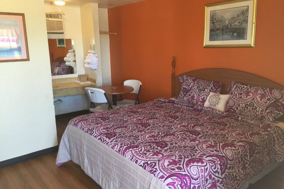 Quarto com cama, escrivaninha e cadeira.