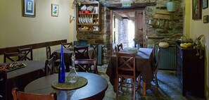 A cozy dining area with stone walls, wooden furniture, and a rustic ambiance. - La Casona de Amaido (San Tirso de Abres)
