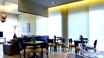 A modern dining area with a mix of seating options, including a booth and individual tables.