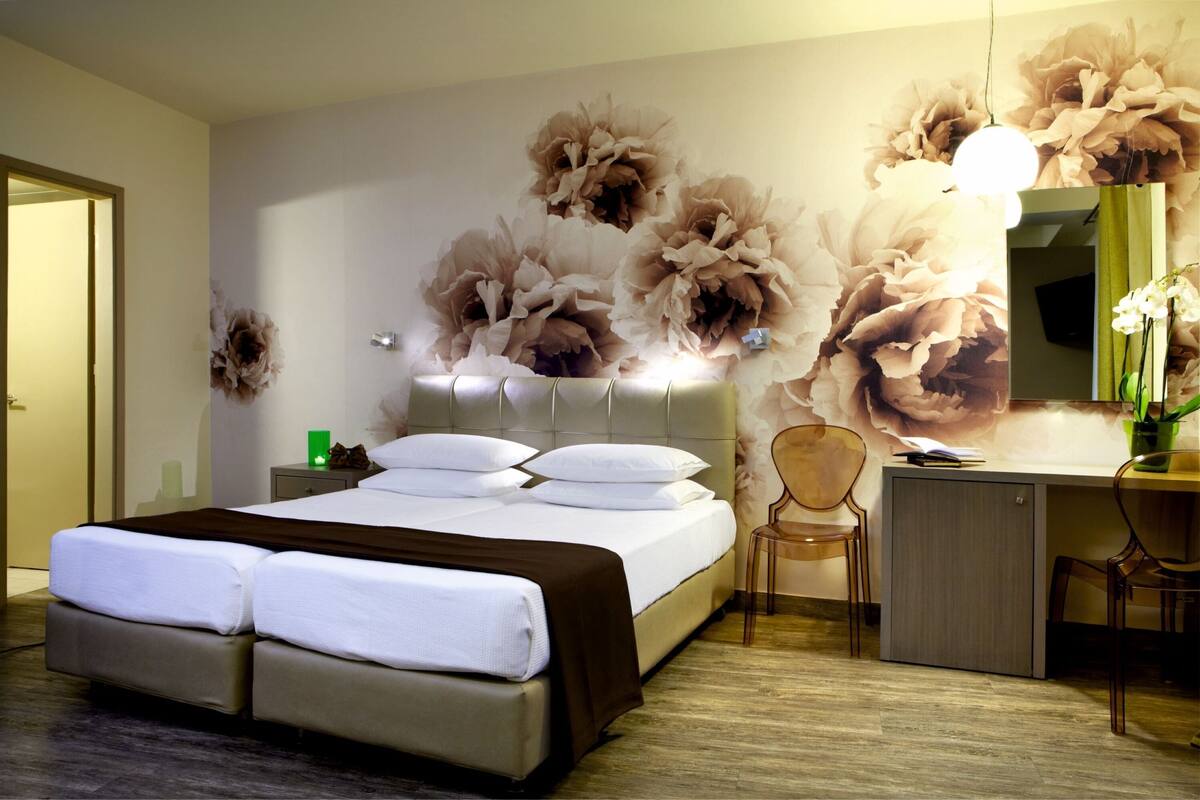 Een moderne hotelkamer met een groot bed, een bureau en een stoel.