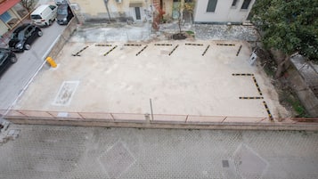 Un parking doté d’une surface goudronnée et délimité par une clôture.