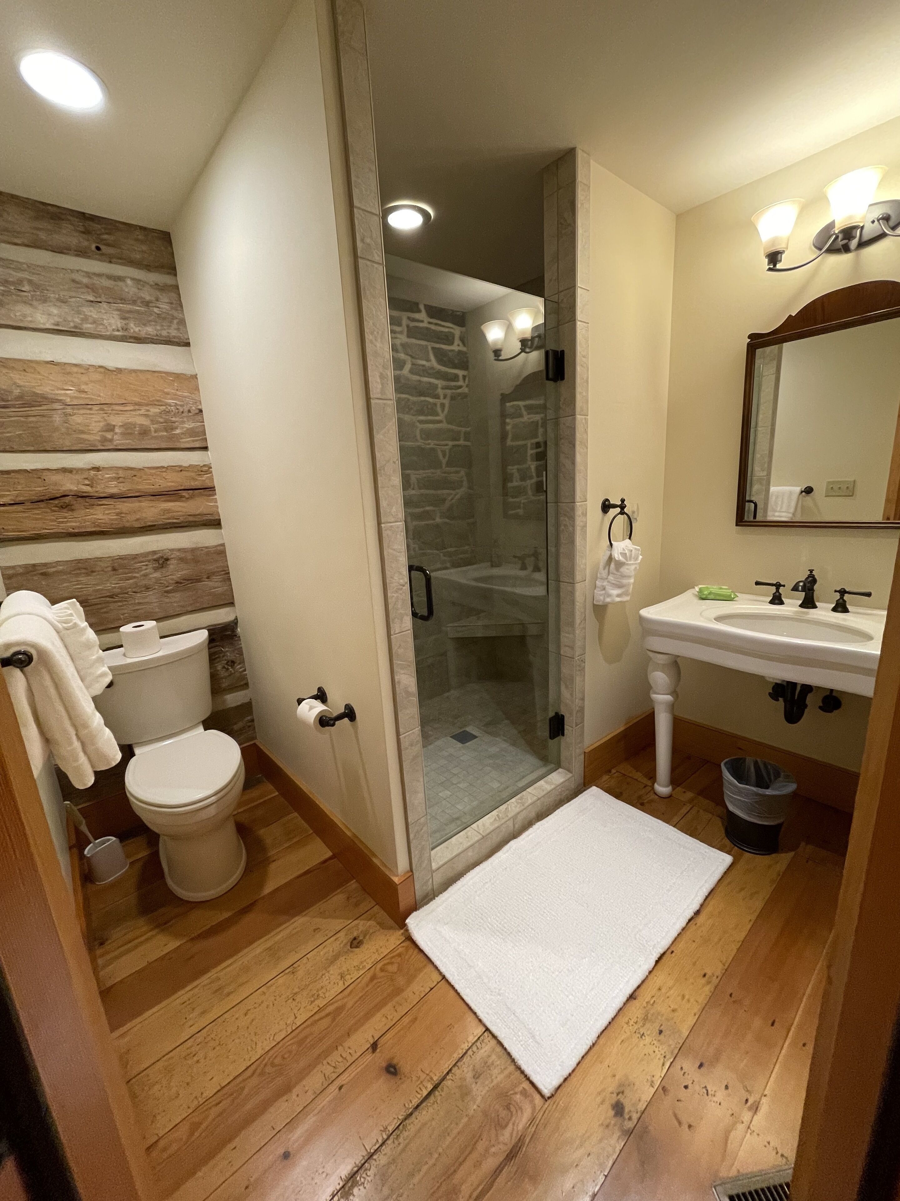 Ein Badezimmer mit Toilette, Waschbecken, Dusche und einer Duschkabine.
