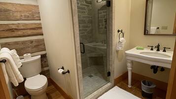Ein Badezimmer mit Toilette, Waschbecken, Dusche und einer Duschkabine.