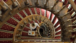 A spiral staircase with a wooden design and a red patterned carpet. - Konstantinoupolis Hotel - Adults friendly (Corfu)