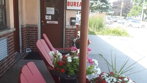 A building entrance with a sign reading "OFFICE BUREAU" and a row of red chairs outside.