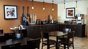 A restaurant with a counter, chairs, and a coffee machine. - Trend Mountain Hotel & Conference Centre (Tumbler Ridge)