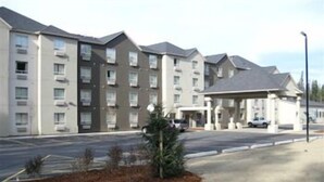 A multi-story hotel with a parking lot and a covered entrance. - Trend Mountain Hotel & Conference Centre (Tumbler Ridge)